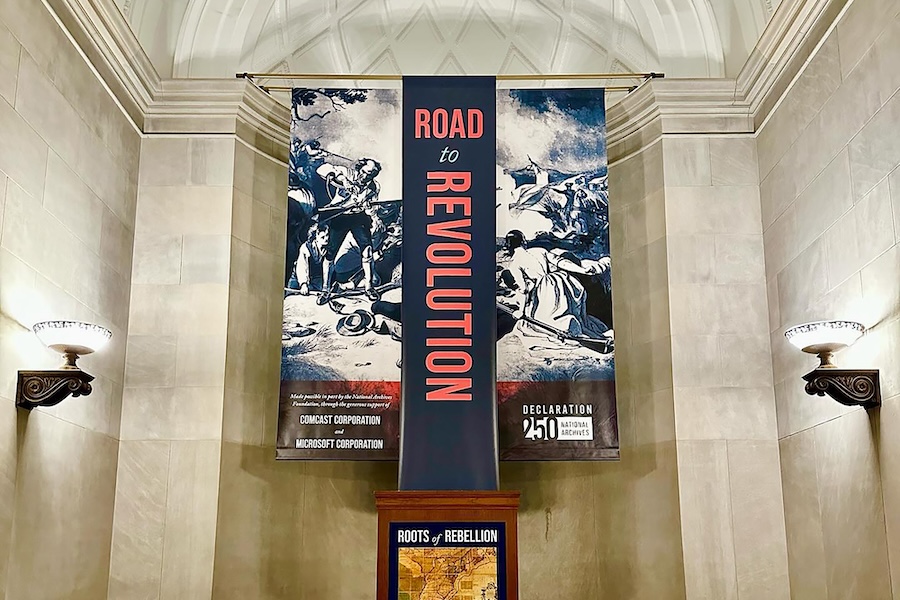 The Road to Revolution exhibit at the National Archives features historical banners, informational panels and documents related to the American Revolution.