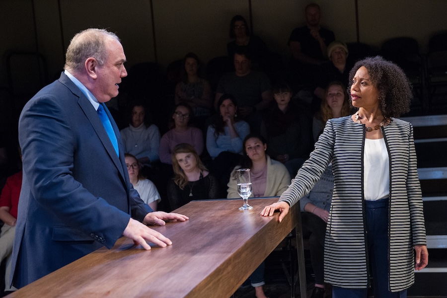 A dramatically staged courtroom scene, where a lawyer approaches the bench. 