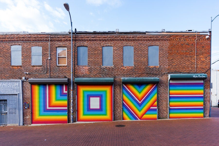 Four garage doors painted with bright, rainbow letters that spell LOVE. 