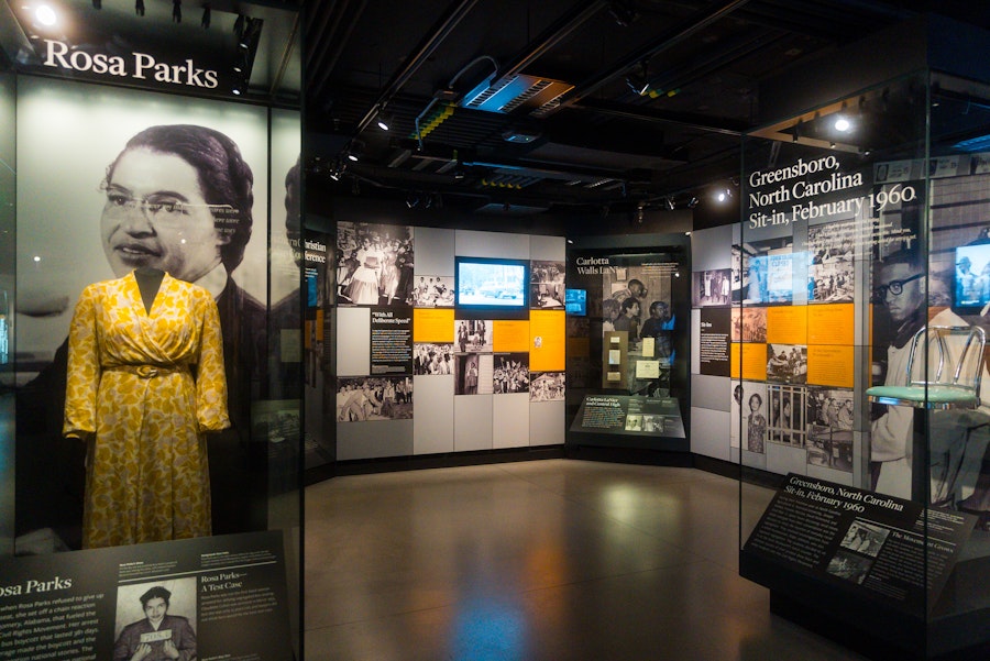 An exhibit displays Rosa Parks' yellow dress alongside historic photos and civil rights information at the National Museum of African American History and Culture.