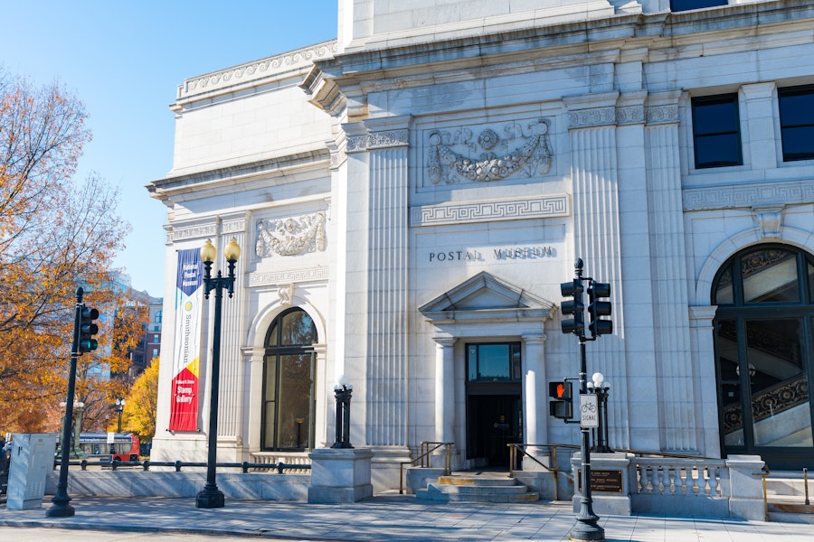 The front of the Postal Museum with grand neoclassical architecture lit by clear daytime sun.