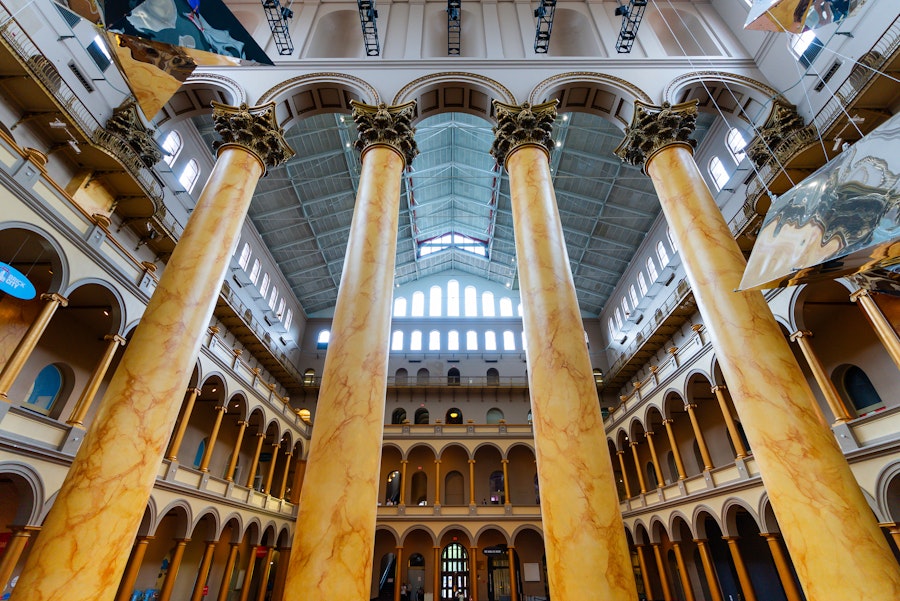 Interior view of the National Building Museum featuring massive Corinthian columns and a vaulted ceiling.