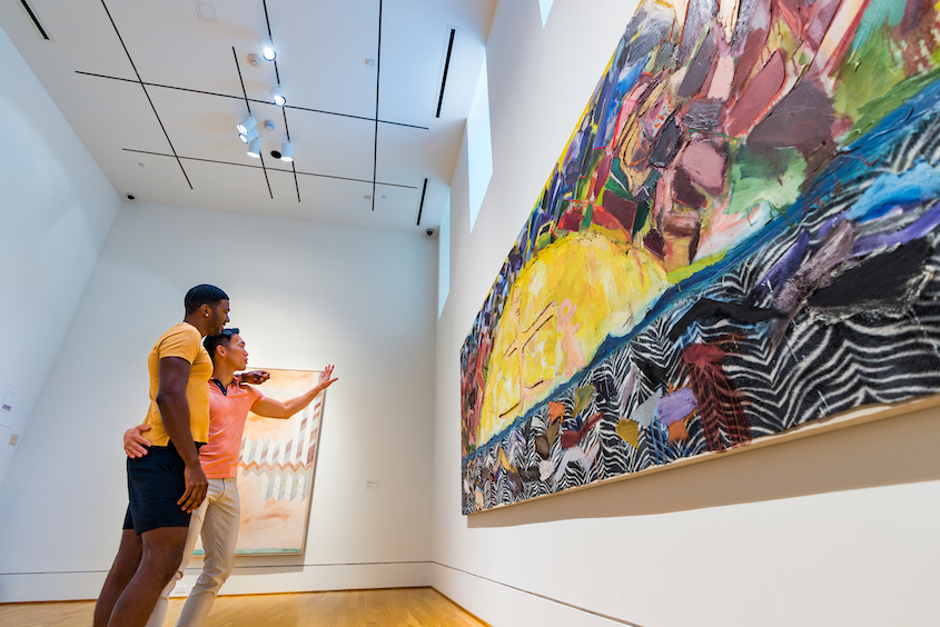 Two people admire a large colorful painting at The Phillips Collection.