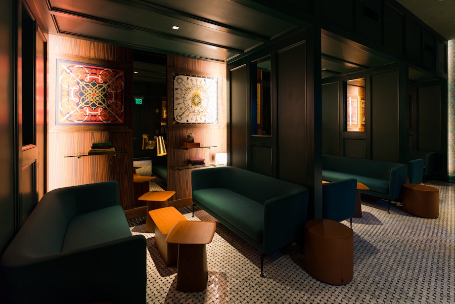 Chic and modern lounge seating at The Duck & The Peach, featuring dark green sofas, patterned floors and soft ambient lighting.