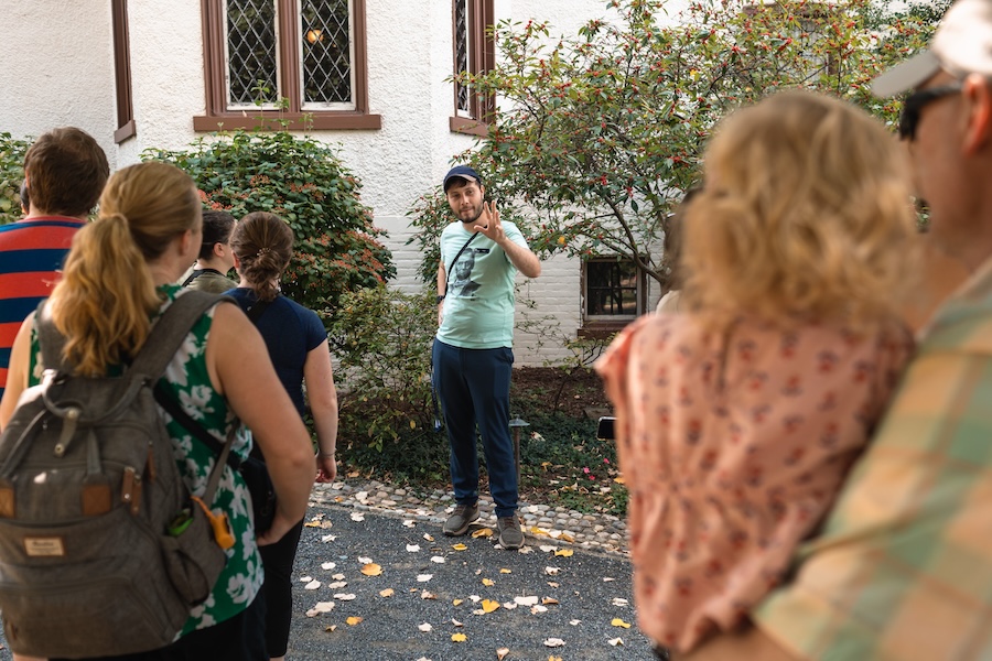 A guide gestures while speaking to a group of visitors during an outdoor tour at President Lincoln’s Cottage in Washington, DC.