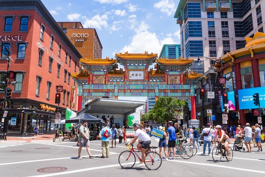 People on foot and bikes gather under the Chinatown Friendship Archway during an Open Streets event in Washington, DC.