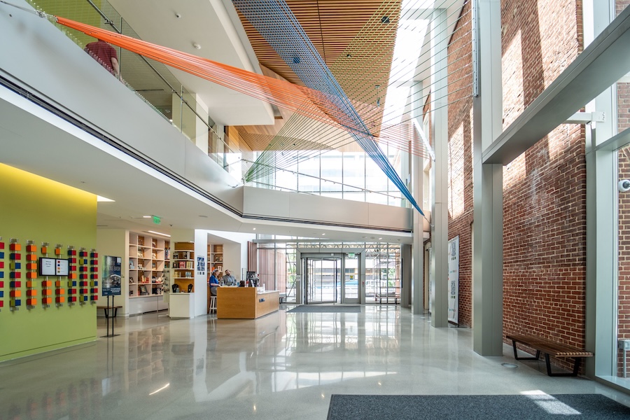 The light-filled lobby of the Capital Jewish Museum features a colorful suspended art installation and modern interior design.