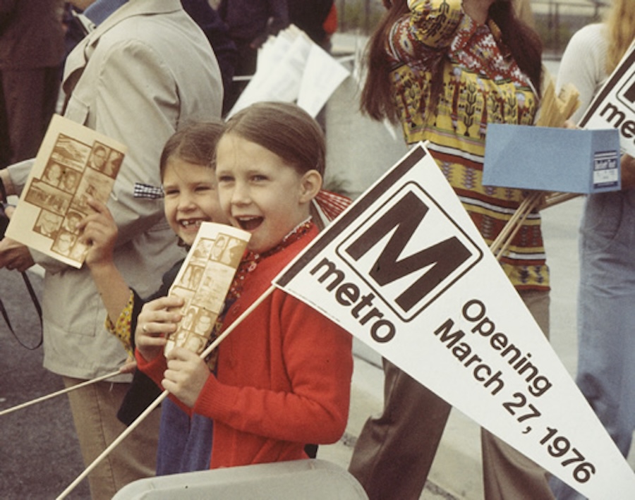 Child holding a Metro sign at an opening day parade, March 27, 1976.