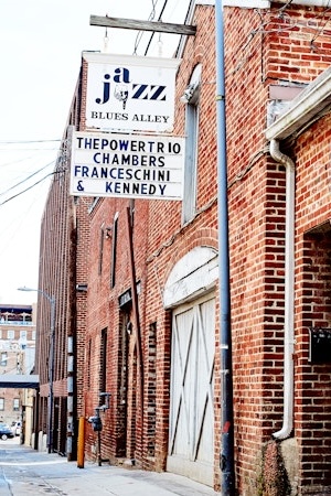 J&amp;J’s Alley sign beside brick building on a quiet city street.