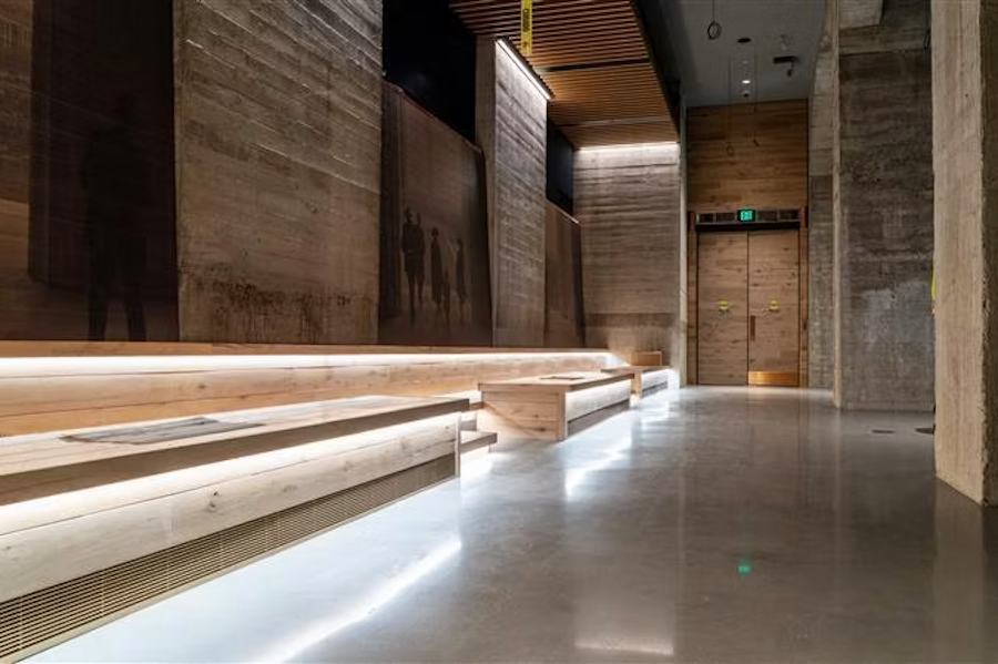 Empty modern hallway with wooden benches and soft floor lighting
