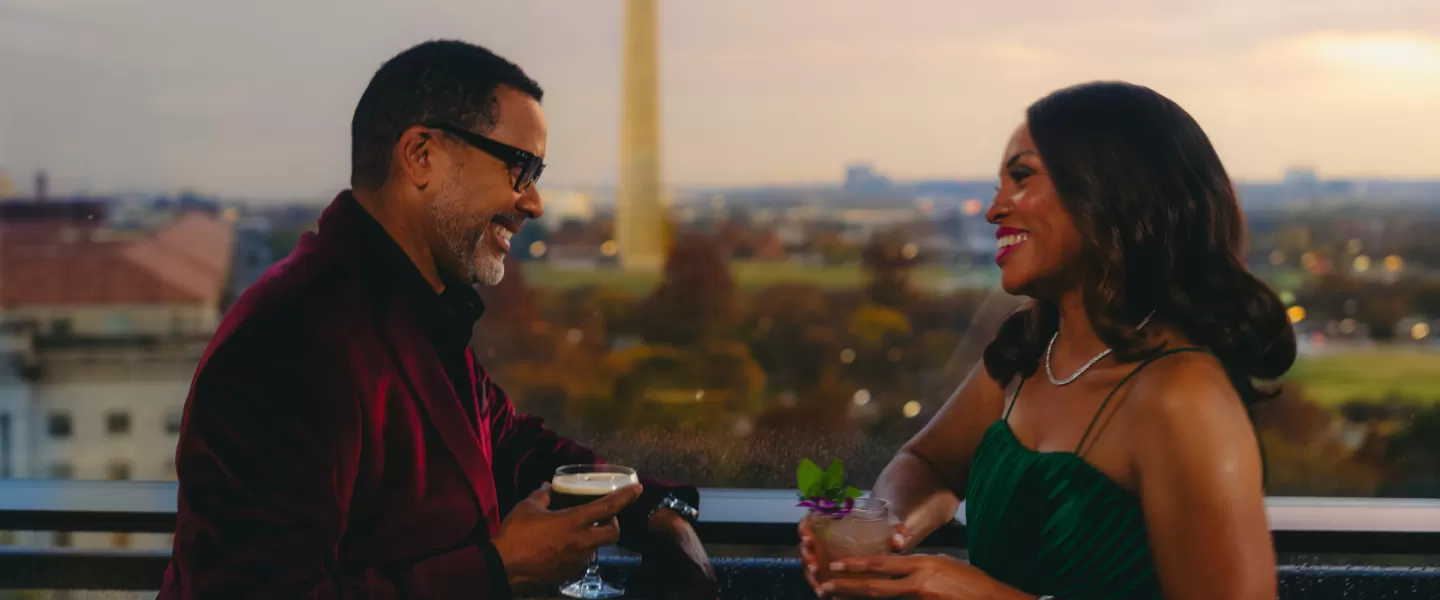 The Smithsonian National Museum of African American History and Culture stands out under a sunny sky with the Washington Monument visible in the background.