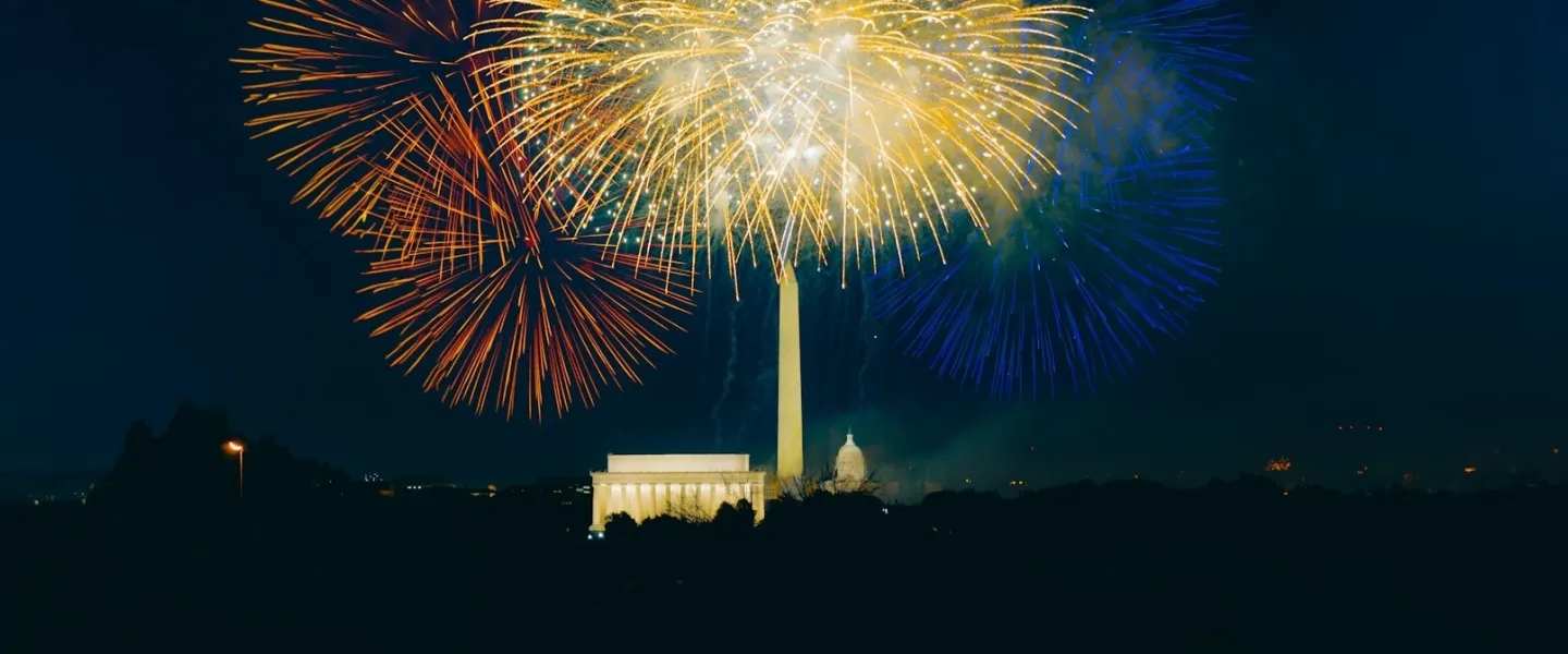 Colorful fireworks light up the night sky over the Washington Monument, Lincoln Memorial, and U.S. Capitol in Washington, DC, during a Fourth of July celebration.
