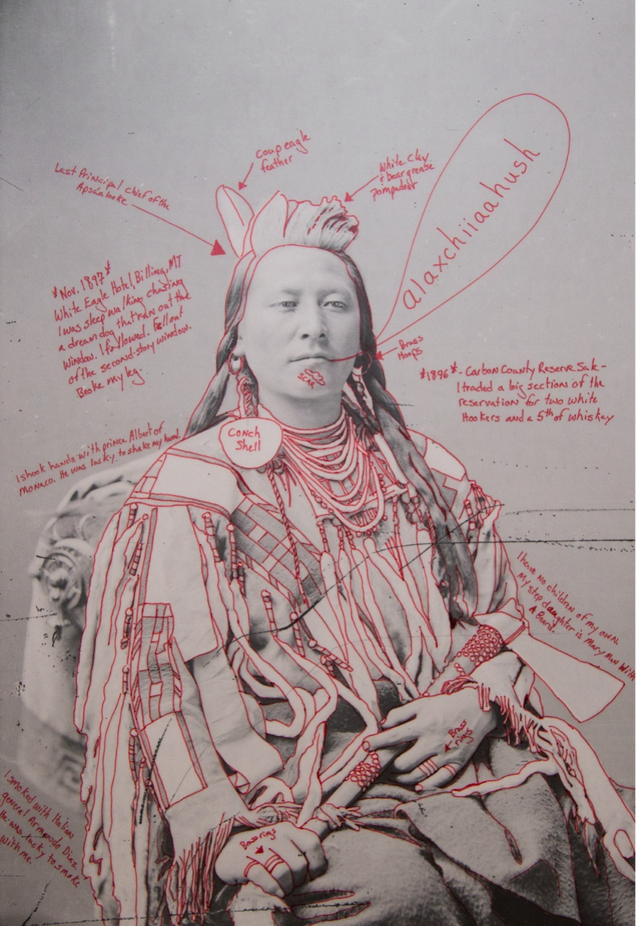 A historical black-and-white portrait of a Native American man annotated with red handwritten notes, detailing personal and cultural elements.