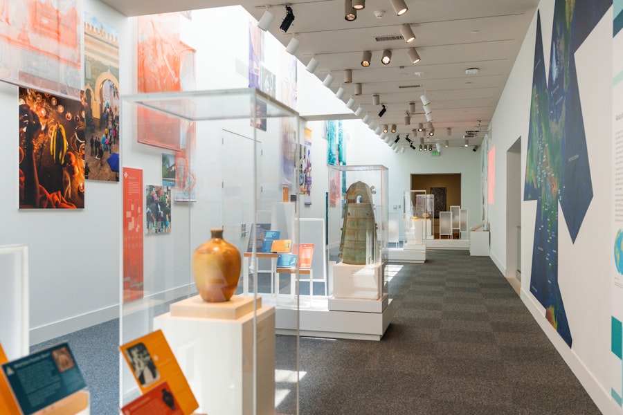 A sunlit gallery showcases Asian artifacts and cultural items in sleek glass cases at the National Museum of Asian Art.