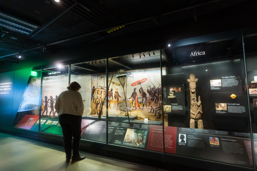 A visitor explores the Africa exhibit at the Smithsonian National Museum of African American History and Culture in Washington, DC, featuring artifacts and interpretive panels on early African civilizations and the transatlantic slave trade.