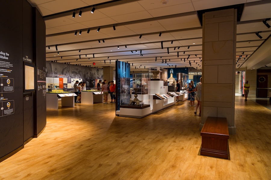 Visitors explore exhibit cases and historical displays inside the U.S. Capitol Visitor Center’s museum gallery.